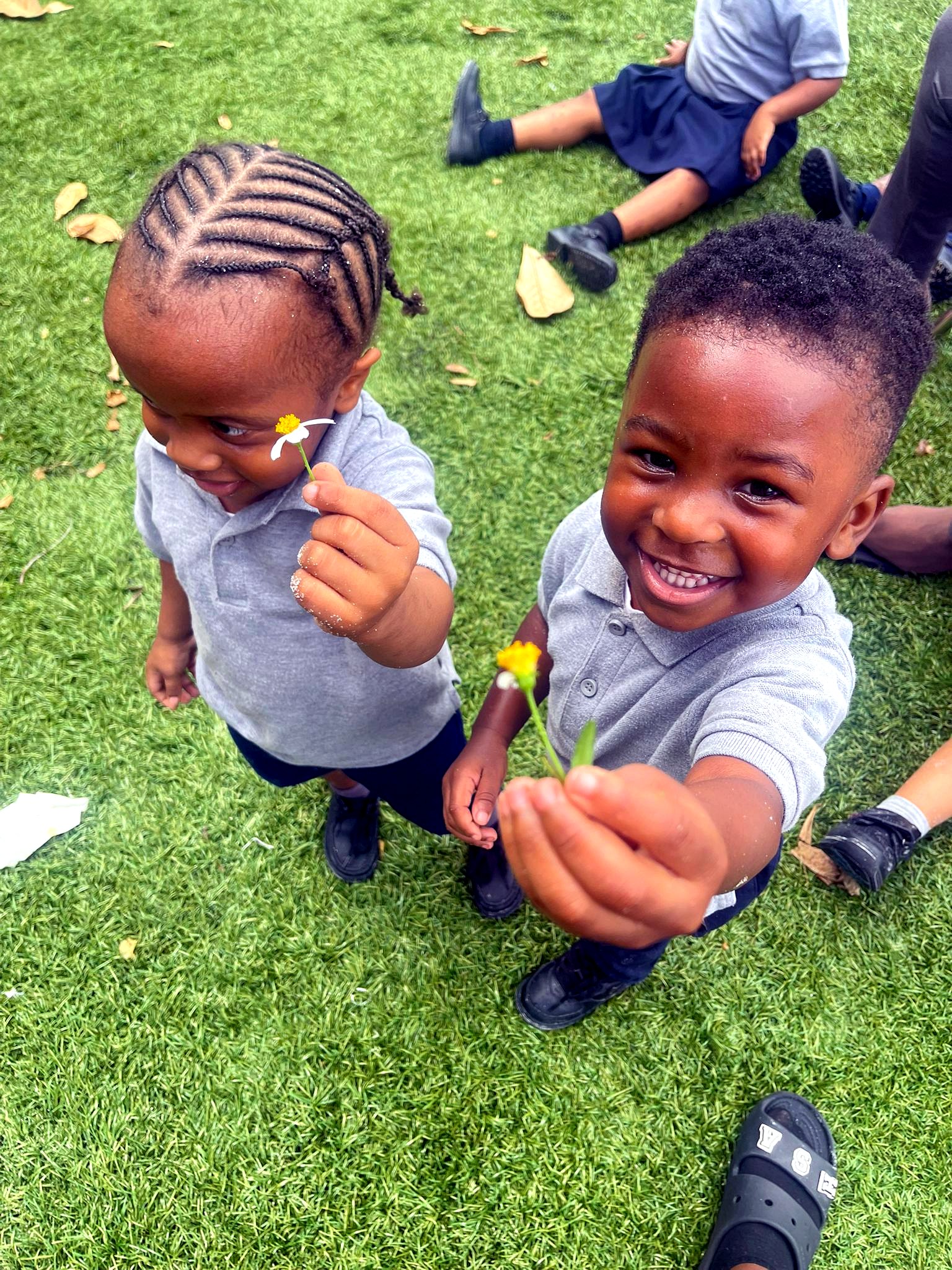 Students exploring with flowers on the playground
